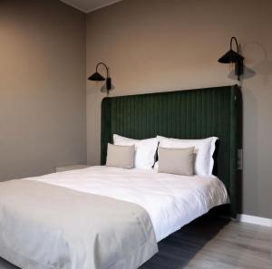切尔诺夫策R.HOTEL的一张带绿色床头板和白色枕头的大床