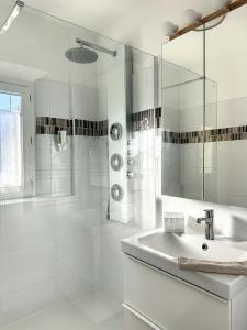 圣艾格夫Le Clos de Saint Aygulf的白色的浴室设有水槽和淋浴。