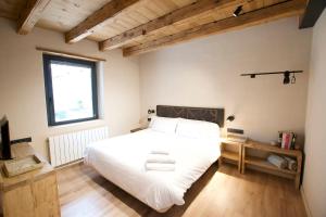 阿尔普Mas Cal Rus的卧室设有一张白色大床和一扇窗户。