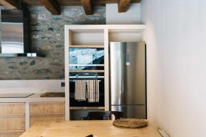 阿尔普Mas Cal Rus的厨房配有不锈钢冰箱和木桌