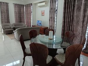 Kampong KerubongDhuha Homestay的客厅配有玻璃桌和椅子