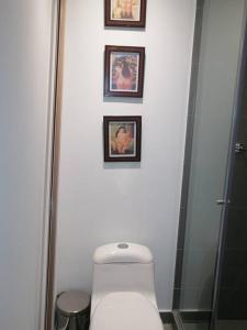 波哥大Apartaestudio Bogotá Colombia的一间带卫生间的浴室和墙上的三张照片