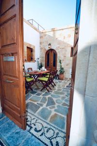 阿彻奇洛斯Villa Patitiri Traditional House的通往带桌椅的天井的开放式门