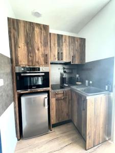 波城Magnifique Appartement Hypercentre - Le Charly的厨房配有木制橱柜和不锈钢用具