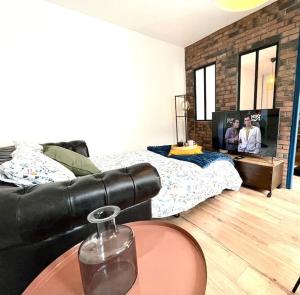 波城Magnifique Appartement Hypercentre - Le Charly的客厅配有黑色真皮沙发和电视