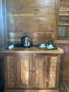 金塔马尼Black Lava Hostel and Lodge的木制橱柜,上面有茶壶