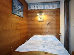 莱索尔Appartement Les Orres, 2 pièces, 6 personnes - FR-1-322-568的卧室配有木墙内的一张床
