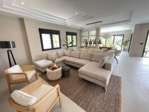 马贝拉NEW LUXURY VILLA : 7 BEDROOMS : POOL : GYM : SPA的客厅配有沙发和桌子