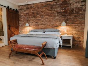 DargleStar Dam Lodges的一间卧室设有一张床和砖墙