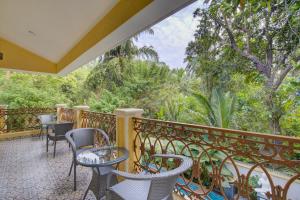萨利加奥Tropical villa by Happyinch的阳台配有桌椅和树木