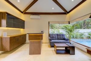 萨利加奥Tropical villa by Happyinch的厨房以及带沙发和游泳池的起居室。