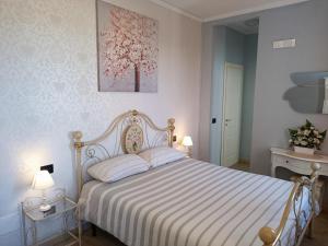 莱萨B&B VILLA PREZIOSA LAGO MAGGIORE的卧室配有一张带白色粉红色床罩的床。