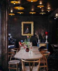 巴黎Hôtel La Nouvelle République & Hammam的一间带木桌和椅子的用餐室