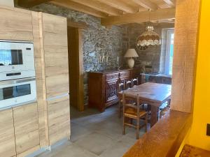 莱萨卡Fondamaria - Alojamiento rural的厨房配有木桌和炉灶。 顶部烤箱