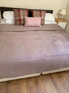 彭赞斯The Dock Inn的一张带紫色棉被和粉红色枕头的床