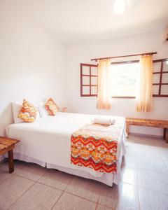 乌巴图巴Pousada Flores do Lázaro的卧室配有白色的床和窗户。