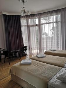 科布列季FRESH Hotel Kobuleti的酒店客房设有两张床和窗户。