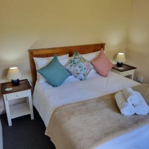伊丽莎白港小路易莎度假屋的一间卧室配有两张带枕头和两张桌子的床。