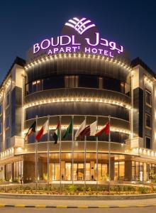 布赖代Boudl Al Rawdah的一座在晚上有旗帜的建筑
