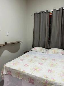 伊塔雷马Casa Vento Maré.的一间卧室配有一张带花卉棉被的床