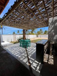 伊塔雷马Casa Vento Maré.的一个带绿色长凳的庭院,位于木制凉棚下