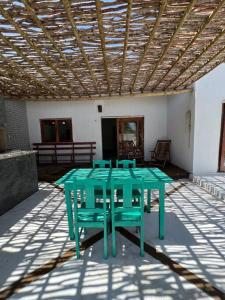伊塔雷马Casa Vento Maré.的天井上摆放着绿色的桌椅
