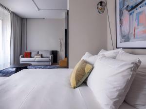 美因河畔法兰克福numa I Bloc Rooms & Apartments的一间卧室配有带白色床单和枕头的床。