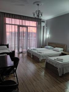 科布列季FRESH Hotel Kobuleti的一间卧室配有两张床和一张桌子及椅子