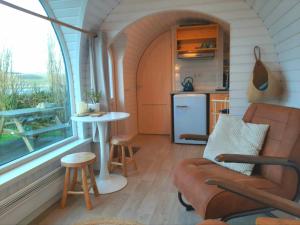 卡兰茨奥赫Tiny House De Boet, in Natuurgebied en vlakbij het Strand的客厅配有沙发和桌子