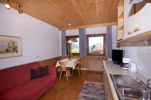 拉古多Apartments Gasserhof的客厅配有红色的沙发和桌子