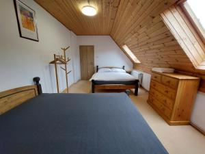 KrasliceSki/Bike Villa Sapporo ⃰ ⃰ ⃰的阁楼卧室设有1张床和木制天花板