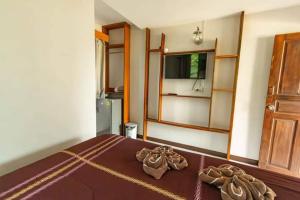 班邦宝BangPo Resort的一间卧室配有一张带棕色床单的床和一扇门。