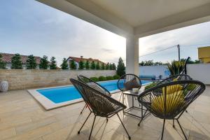 利纳迪奇Villa Insula的一个带桌椅的庭院和一个游泳池