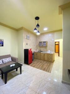 艾卜哈ديار البساتين المنسك للشقق الفندقية - Diyar Al Basateen Hotel Apartments的带沙发和红色冰箱的客厅