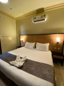 艾卜哈ديار البساتين المنسك للشقق الفندقية - Diyar Al Basateen Hotel Apartments的一间酒店客房,配有一张带毛巾的床