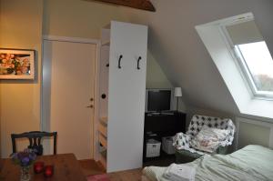 赫尔辛堡Aplagårdens vingård的卧室设有白色门、椅子和桌子