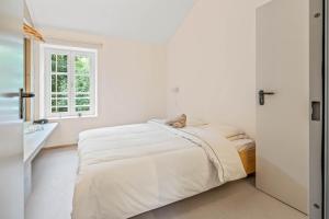 迪弗当日Maison Lasauvage的白色的卧室设有床和窗户