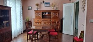 Le GenestLe Genest St Isles的一间带木桌和椅子的用餐室