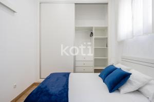 福恩吉罗拉Koti Rentals - Casita Plaza España的卧室配有白色的床和蓝色枕头