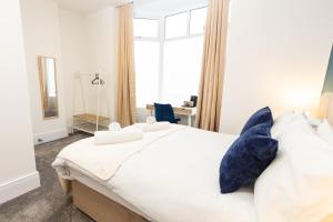 奥尔德姆Suite 1 - Lovely Ensuite in Oldham Sociable House的一间卧室配有一张带蓝色枕头的大床