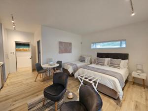 杰弗里湾Point Villa的一间卧室配有两张床和一张桌子及椅子
