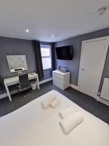布莱克浦皇后广场酒店的卧室配有一张白色的床、书桌和电视。