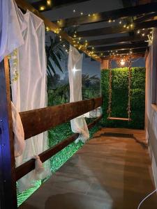莫日-达斯克鲁济斯Alugo espaço com piscina + Jacuzzi!的门廊设有1个带秋千和灯的围栏
