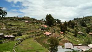 HuillanopampaBLUE SKY Lodge Taquile的山丘上小村庄的空中景观