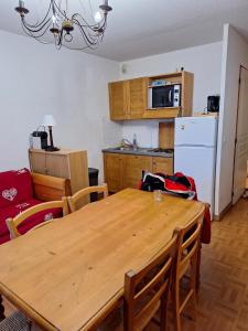 土绪尔Appartement dans un chalet, résidence avec piscine的厨房以及带木桌的用餐室。