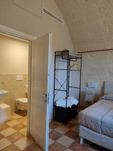 马泰拉Tenuta Danesi & Bubble Rooms的一间卧室配有一张床,浴室设有卫生间