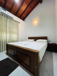阿努拉德普勒Langama Thena - ළඟම තැන的一间卧室配有一张木架大床