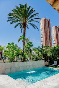 贝尼多姆Villa JAP的棕榈树和一个带喷泉的游泳池