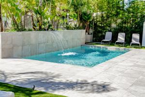 贝尼多姆Villa JAP的一个带两把椅子的游泳池和一个喷泉