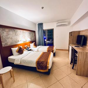 亚喀巴阿卡维斯塔套房酒店的酒店客房设有两张床和电视。